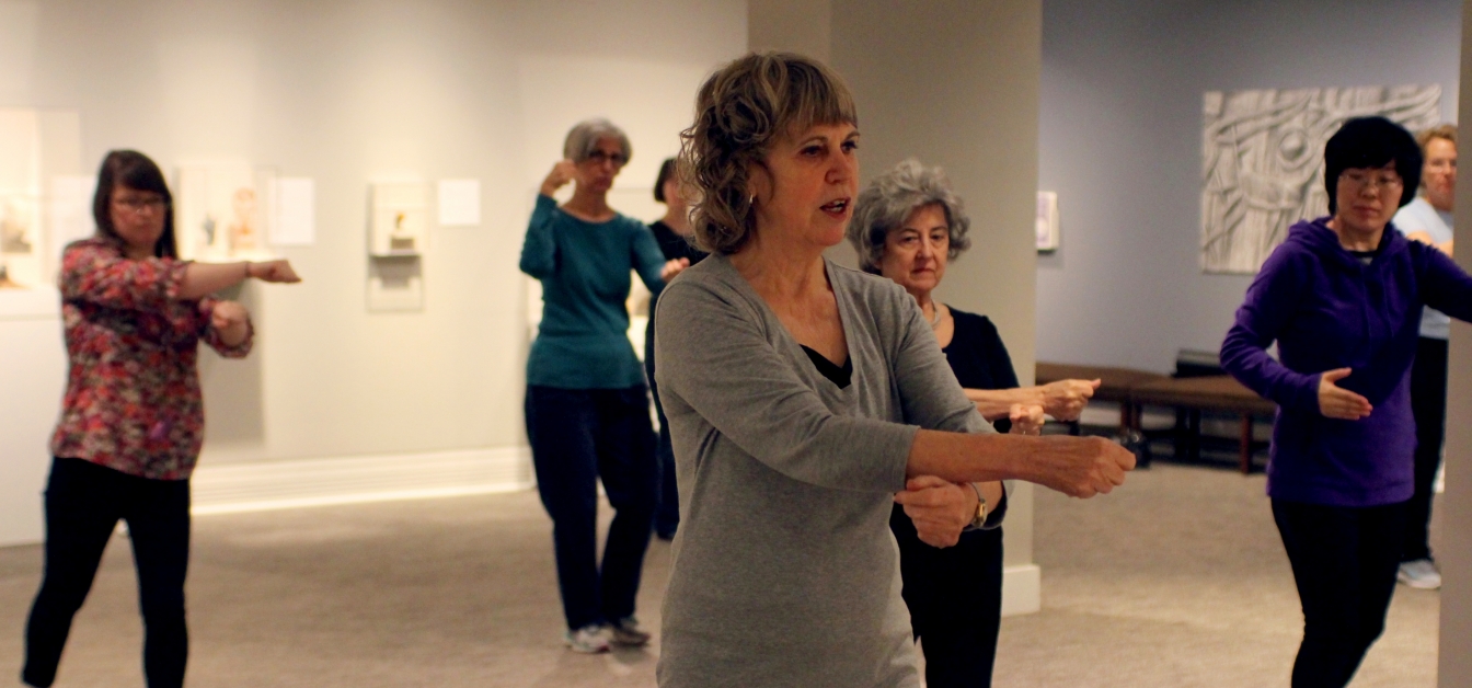 Instructor and participants practice Tai Chi in the Ackland's galleries.